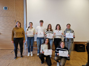7 stolze Schüler*innen mit ihren DELE-Zertifikaten und ihrer Spanischlehrerin Frau Grundler